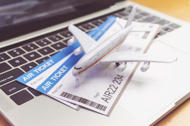 Foto avión y dinero en la computadora portátil