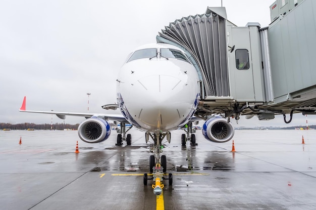 El avión está estacionado en el aeropuerto con una pasarela esperando el embarque de pasajeros