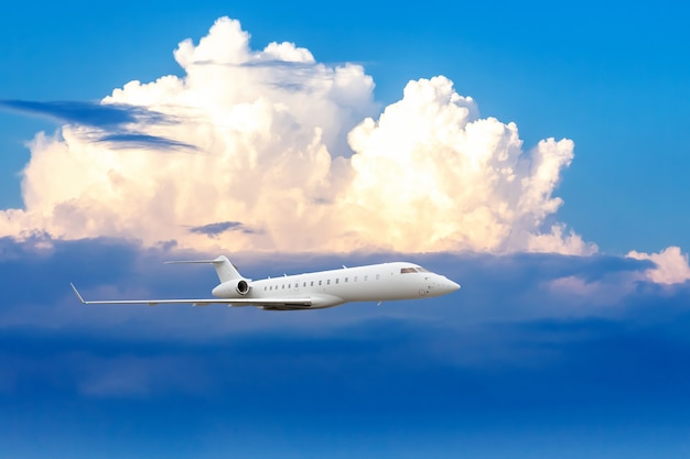 Avión jet de negocios volando a gran altitud por encima de las nubes