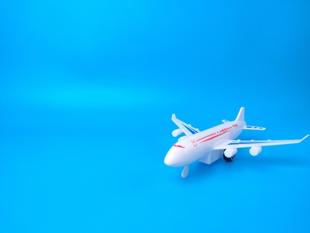 Avión de juguete blanco sobre un fondo azul con espacio de copia