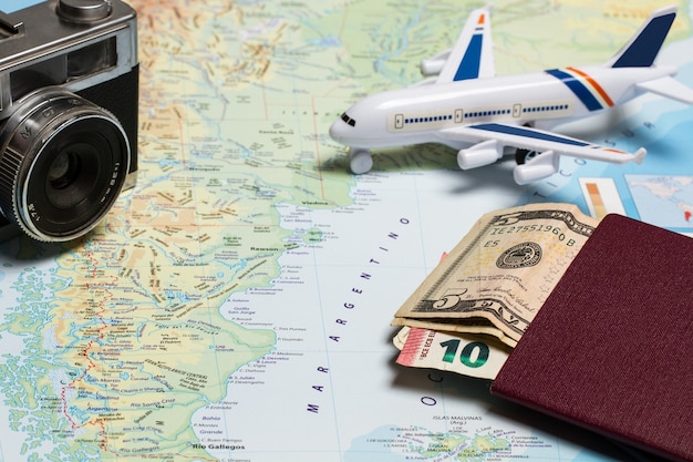Un avión de juguete en un mapa con dinero de pasaporte y una cámara fotográfica