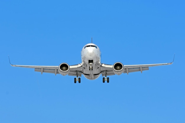 Avión listo para aterrizar volando en el cielo azul con tren de aterrizaje y flaps