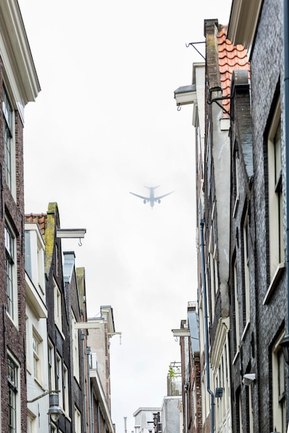 El avión en la niebla vuela sobre casas altas en la ciudad Enfoque selectivo Vertical