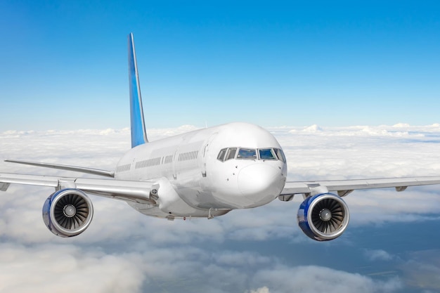 Avión de pasajeros en el cielo azul Avión volando alto a través de las nubes cúmulos Vista de cerca del avión en vuelo
