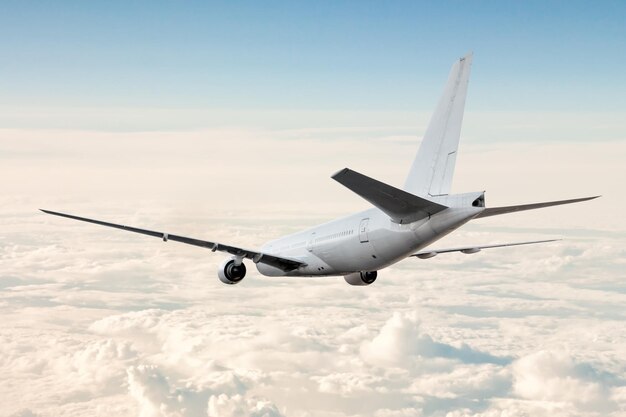 El avión de pasajeros de cuerpo ancho blanco vuela en el aire por encima de las nubes