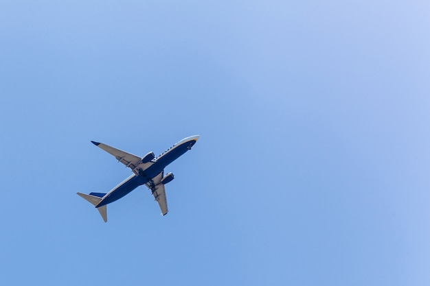 El avión de pasajeros en el fondo del cielo azul claro en un día soleado.