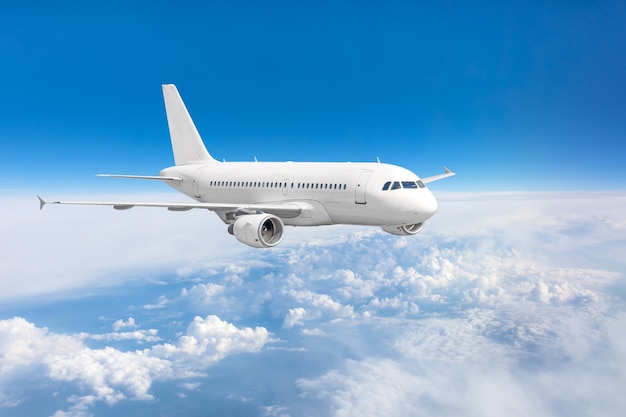 Avión de pasajeros volando por encima de las nubes y el cielo azul.