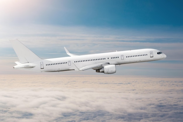 El avión de pasajeros vuela a gran altura por encima de las nubes y el cielo azul