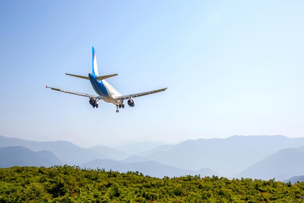 Foto avión de pasajeros vuela sobre un valle montañoso industria del transporte aéreo