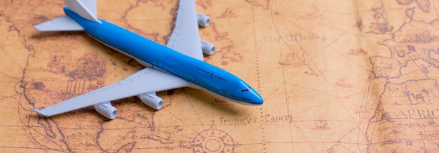 Foto avión pequeño en el mapa para planificar un viaje de vacaciones y accesorios para viajar