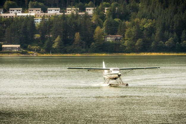 Foto avión de proa o avión de mar que despega de un lago