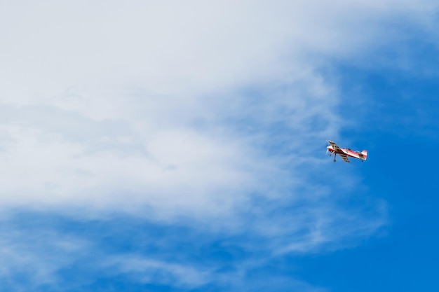 Avión de rayas rojas y blancas volando en el hermoso cielo azul