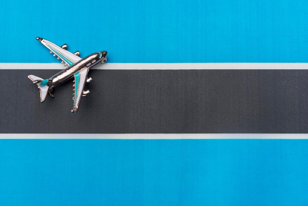 Avión sobre la bandera de Botswana el concepto de viaje