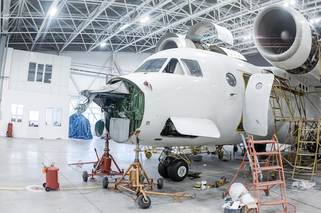 Avión de transporte blanco en el hangar Avión en mantenimiento