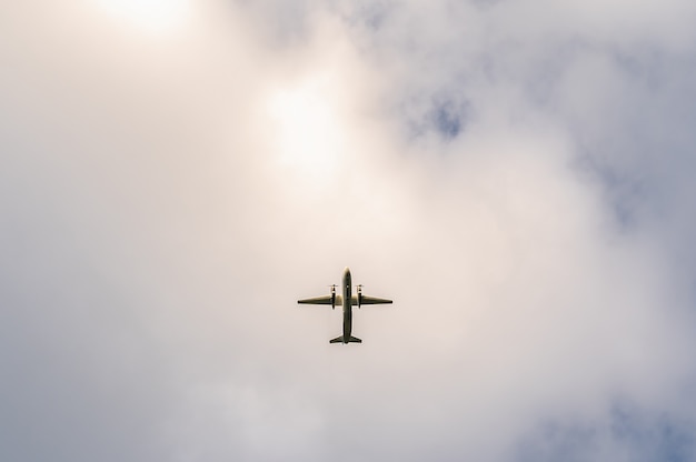 Avión turbohélice bimotor contra un cielo nublado Vista inferior