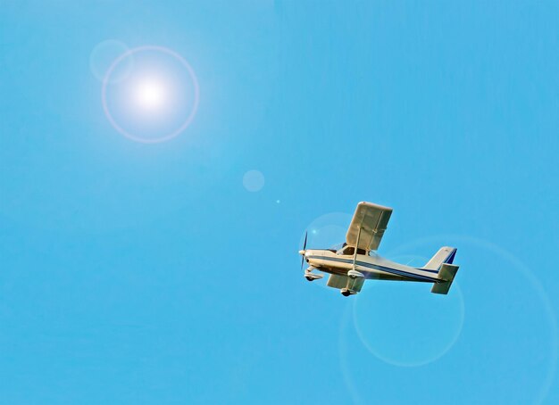 Avión ultraligero bajo un sol brillante