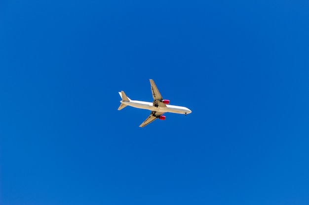 Un avión volando en el cielo azul sin nubes blancas.