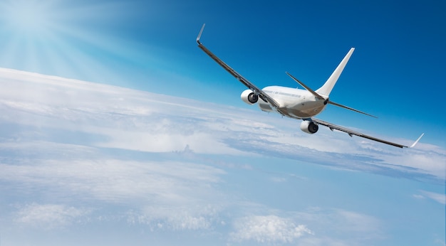 Avión volando hacia el cielo a gran altitud por encima de las nubes blancas