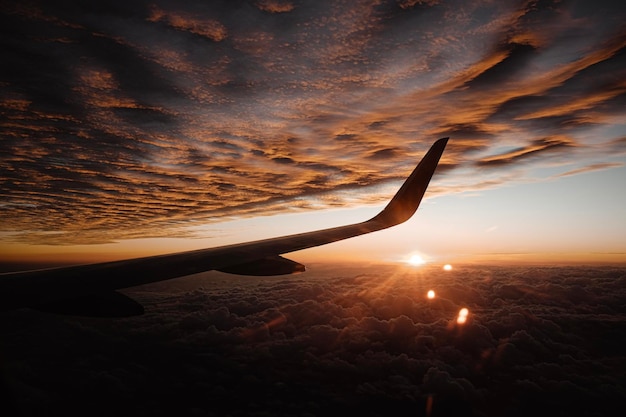 Foto avión volando en el cielo durante la puesta del sol