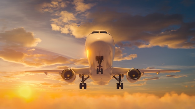 Avión volando sobre nubes dramáticas durante la puesta de sol