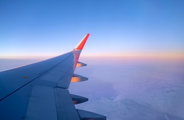 Avión volando en la vista del cielo hasta el ala del avión a través de una ventana