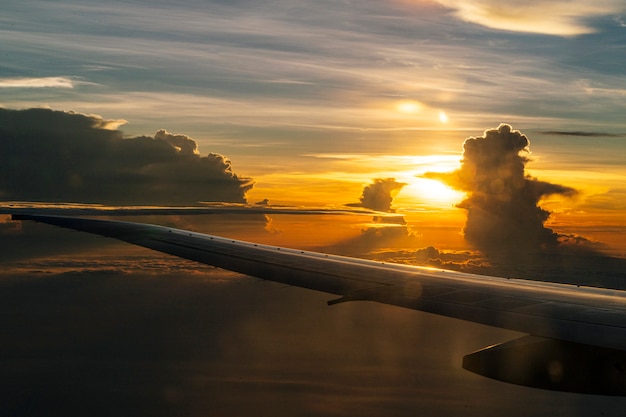 Avión volando vista desde el interior de la ventana en la puesta del sol Hermoso horizonte Concepto de viaje