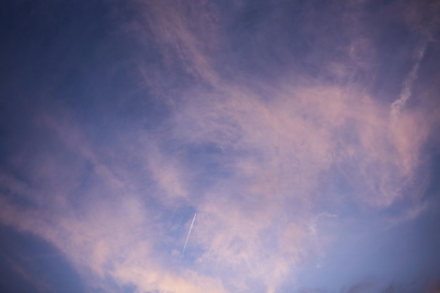 El avión vuela alto en el cielo al atardecer.