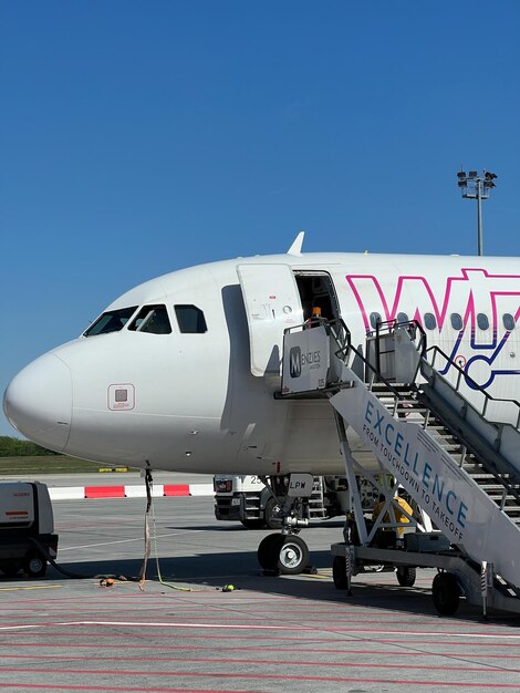 Avión de Wizz Air con una escalera en el primer plano del aeropuerto