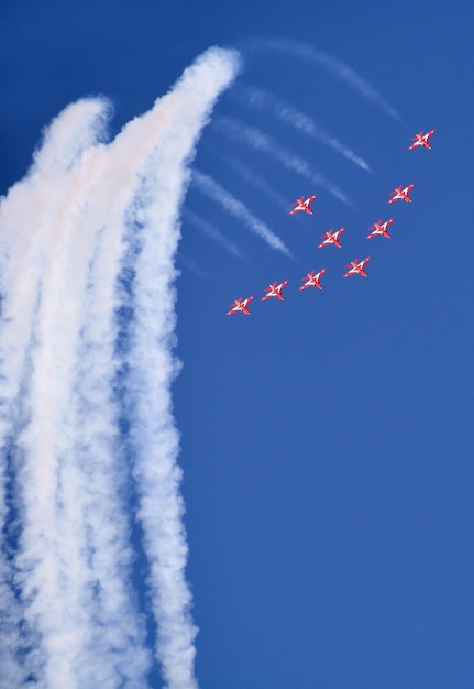 Los aviones de combate militares vuelan en grupo con humo en el cielo azul