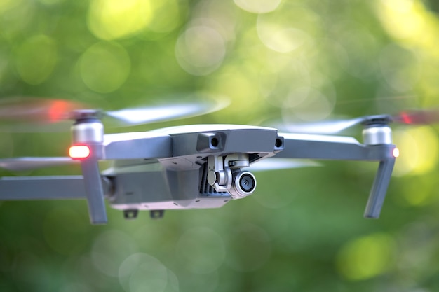 Aviones no tripulados con hélices de rotación rápida borrosas y cámara de video volando en el aire.