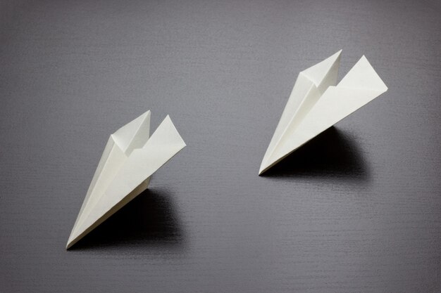 Aviones de papel sobre un fondo oscuro