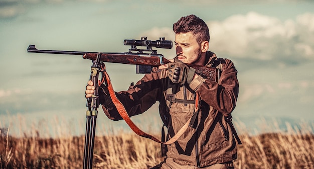 Avistamento do atirador no alvo. O homem está caçando. Rifle de caça de caça. Homem caçador. Período de caça. Homem com uma arma. Fechar-se. Hunter com arma de caça e forma de caça para caçar. Hunter está mirando.