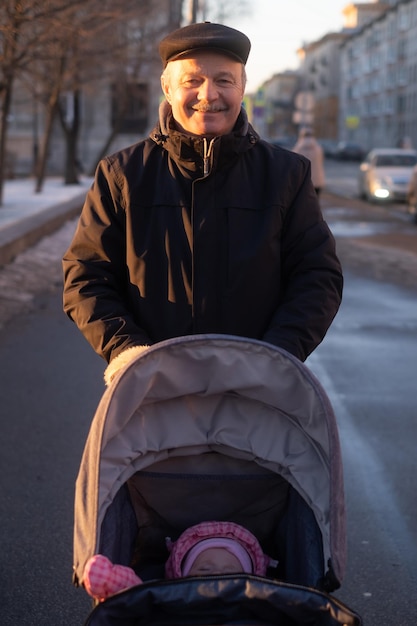 Avô andando com um carrinho de bebê em dia de inverno nevado