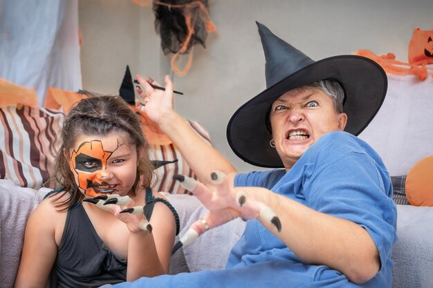 Avó com criança pinta sorrisos para o Halloween