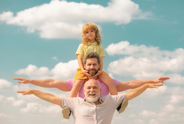 Avô com filho e neto levantando as mãos ou braços abertos voando pais de família de várias gerações