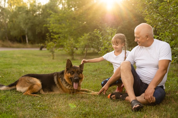 Avô com neta e um cachorro no jardim