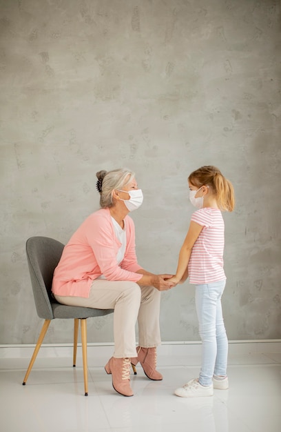 Avó e neta fofa usando máscaras respiratórias