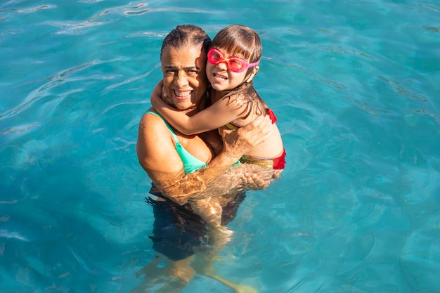 Avó e neta na piscina do hotel aproveitando as férias