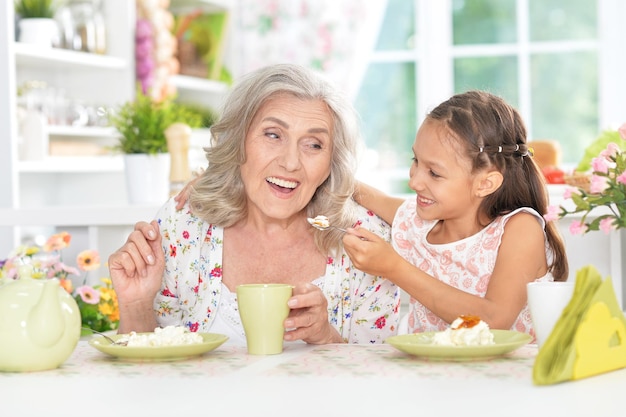 Avó e neta tomando café da manhã juntos na cozinha