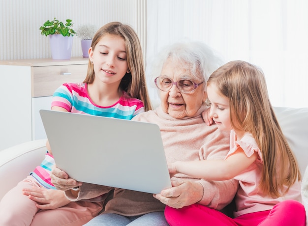 avó e netas usando um laptop