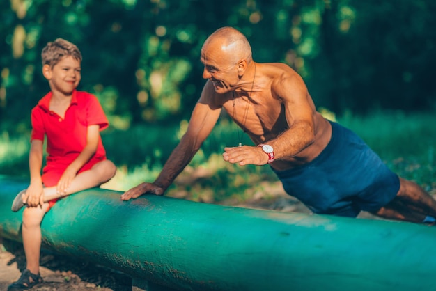 Avô e neto fazendo flexões no parque