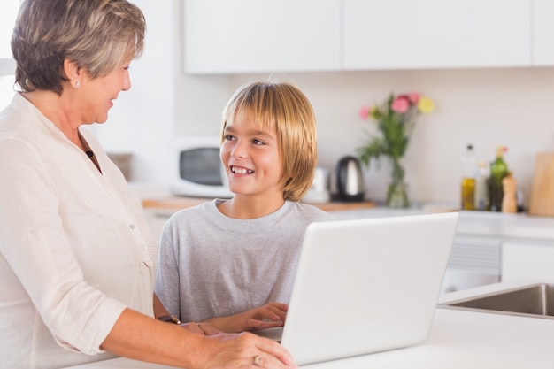 Avó e neto usando laptop e sorrindo