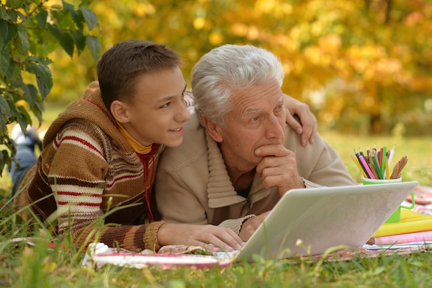 Avô e seu neto desenhando ao ar livre no parque outono