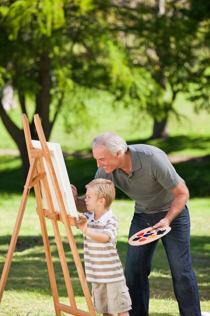 Avô e seu neto pintando no jardim