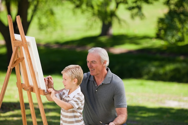 Avô e seu neto pintando no jardim