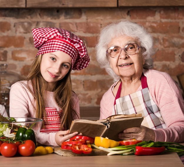 Avó e sua neta sentadas juntas na cozinha