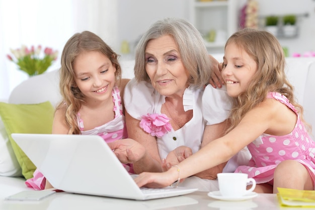 Avó e suas netas usando laptop juntos