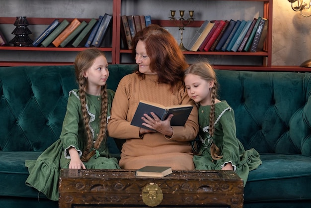 Foto avó feliz e netos lendo livro juntos em casa