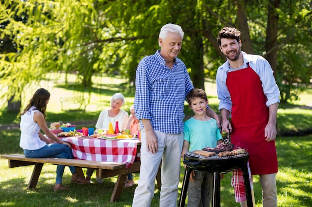 Avô, pai e filho barbequing no parque