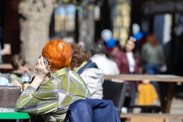 Avó ruiva falando em um telefone celular